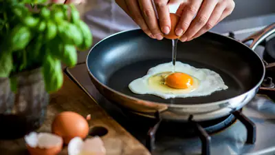 Ovos estrelados a cozinhar sobre uma camada de sementes de sésamo douradas numa frigideira